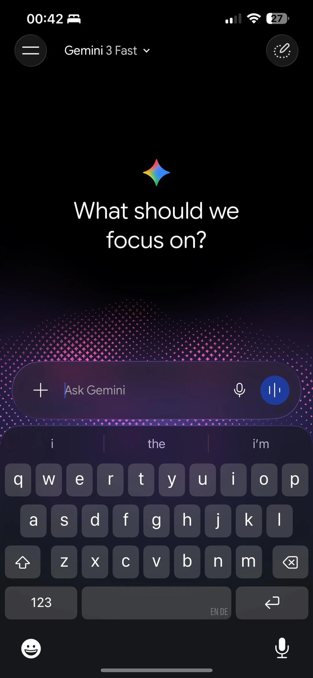 Gemini iOS 새 디자인 — 다크 테마에 *"Gemini 3 Fast"* 모드 선택, 핑크·보라 그라디언트 도트 배경 위에 *"What should we focus on?"* 큰 텍스트, 입력창에 마이크·블루 음성 버튼, 하단에 Liquid Glass 스타일 키보드
