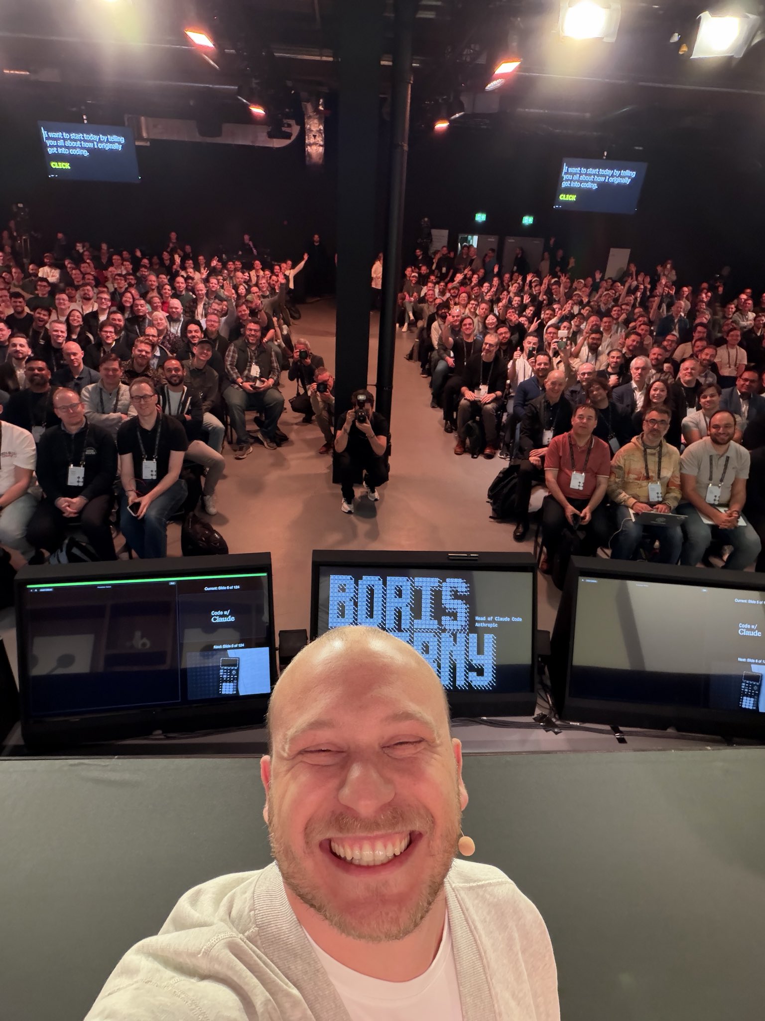 Code with Claude London 무대 — Boris Cherny 본인이 카메라를 향해 셀카, 뒷줄까지 가득 찬 객석과 모니터에 "BORIS CHERNY" 픽셀 로고