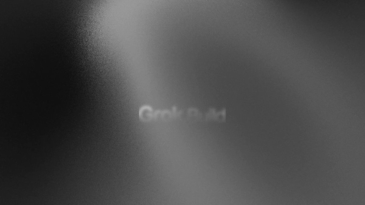 Grok Build 티저 영상 캡처 — 어두운 텍스처 위 <em loading=