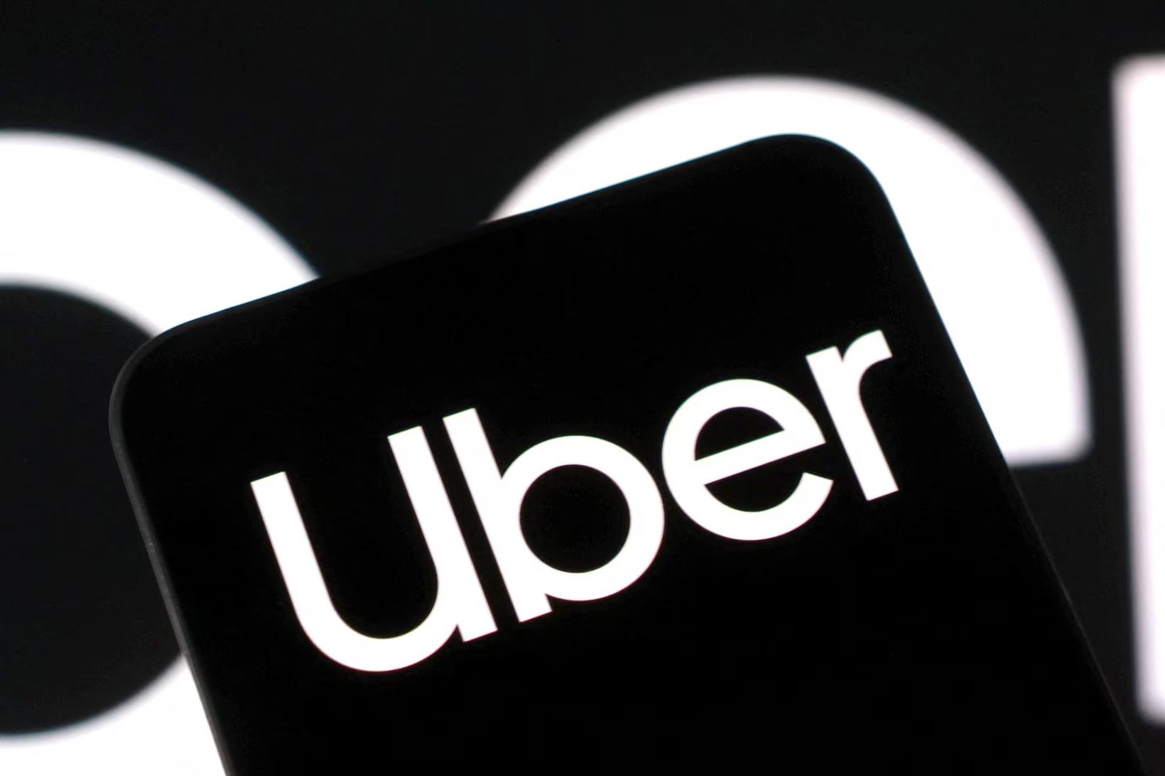 Reuters 스타일 스톡 이미지 — 검은 배경에 Uber 로고만 클로즈업. AI 토큰 비용을 정당화하지 못한다는 발언의 시각적 앵커