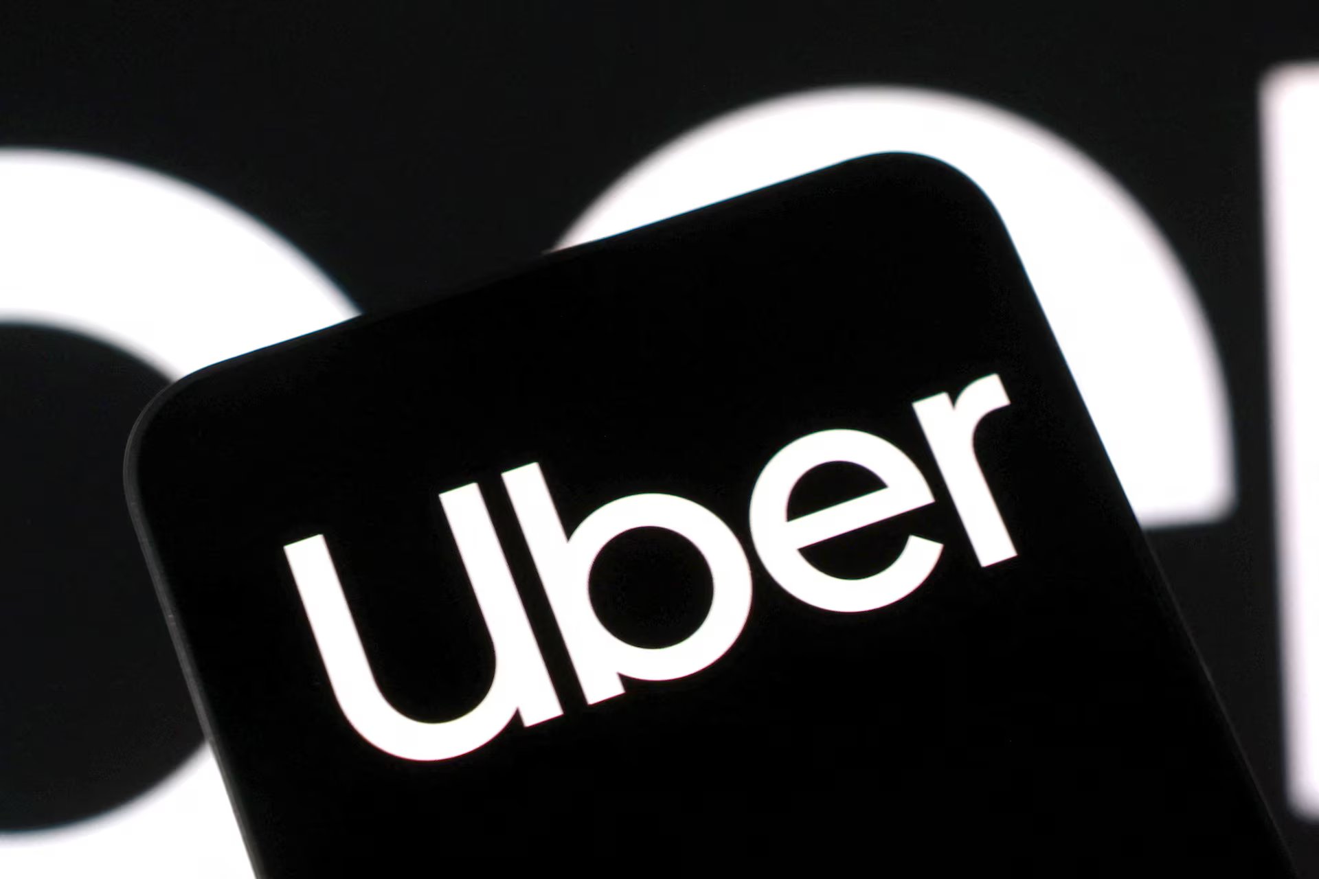 Reuters 스타일 스톡 이미지 — 검은 배경에 Uber 로고만 클로즈업. AI 토큰 비용을 정당화하지 못한다는 발언의 시각적 앵커